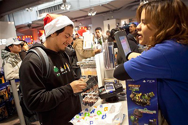 A customer pays for his purchases inside the Toys R Us in Times Square in New York on Thursday, Nov. 24, 2011. The Toys R Us opened at 9PM offering special deals for holiday shoppers. (AP Photo/Andrew Burton)