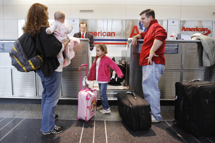 Lori Tempesta, of Falls Church, Va., left, holds her baby Ashlyn Tempesta, next to daughter Elena Tempesta, 3, and husband Anthony Tempesta, as they check in for a flight to Dallas for Thanksgiving, today at Washington's at Ronald Reagan National Airport.
