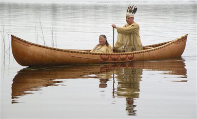 This October 2011 photo provided by the Passamaquoddy tribe shows Chief Joseph Socobasin paddling a birch canoe with his grandmother Joan Dana in Indian Township, Maine. Tribal members built the canoe, a replica of one from the 1800s, using a single piece of birch bark. Though Maine voters rejected a racetrack casino on Nov. 8, 2011, that would have helped bolster the tribe's economy, they are looking to wind, water and land for other means of economic development. (AP Photo/Martin Dana)