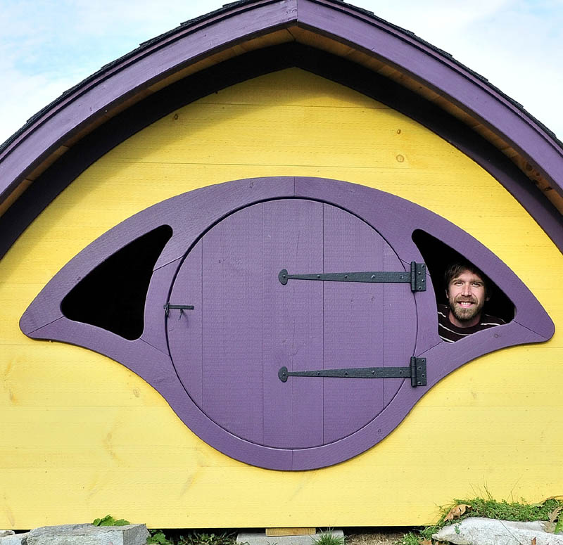 HELLO OUT THERE: Rocy Pillsbury looks out from the inside of a Hobbit Hole playhouse he builds for his Wooden Wonders business in Unity.