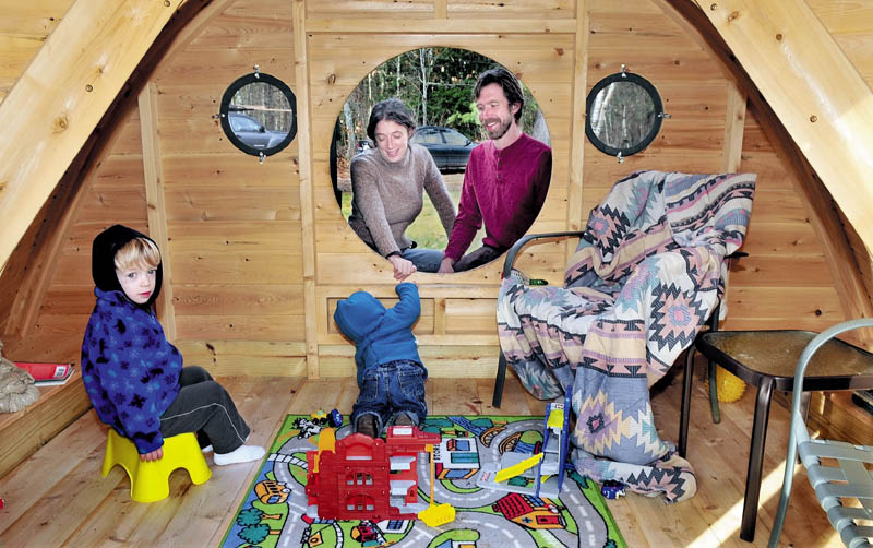 FUN STUFF: Melissa and Rocy Pillsbury watch from a round doorway as their children Richard, left, and Maximus play in one of the Hobbit Hole playhouses they make for their Wooden Wonders business in Unity. The buildings are designed from the J.R.R. Tolkein novels.