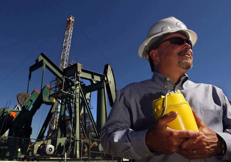 David L. Slater, executive vice president of Signal Hill Petroleum, holds a device that helps the company map out new oil deposits by detecting vibrations.