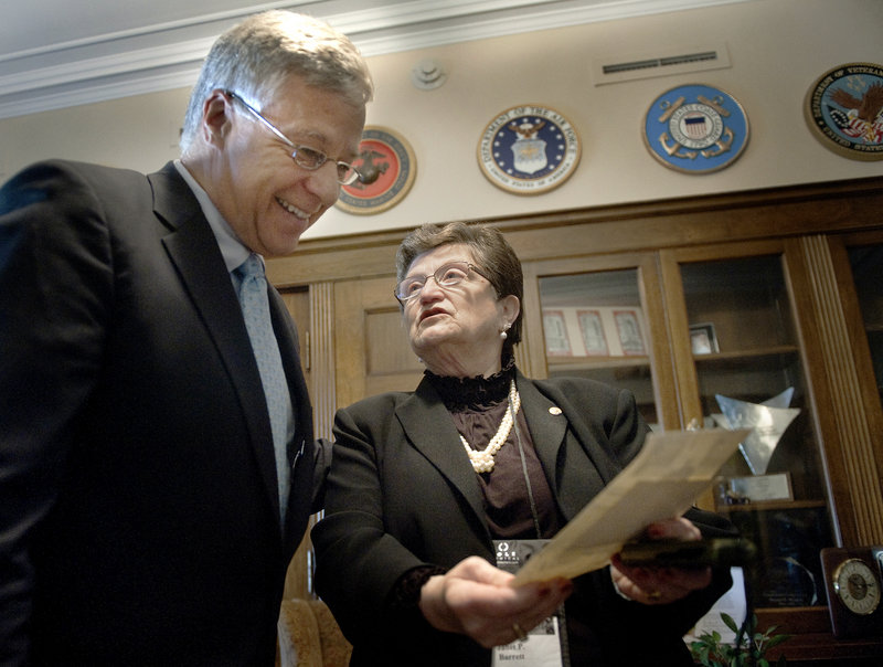 Jan Barrett of Lewiston shares photos of her late father, Lt. Thomas Plourde, with U.S. Rep. Michael Michaud, a Maine Democrat, in his office before a ceremony Wednesday to award the Congressional Gold Medal to Plourde and veterans from the Japanese-American military regiment he helped command during World War II.