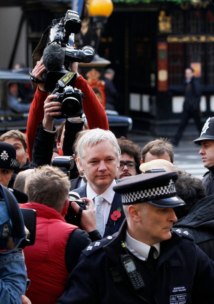 WikiLeaks founder Julian Assange is swarmed by the media in London as he arrives Wednesday for his extradition hearing at the High Court.