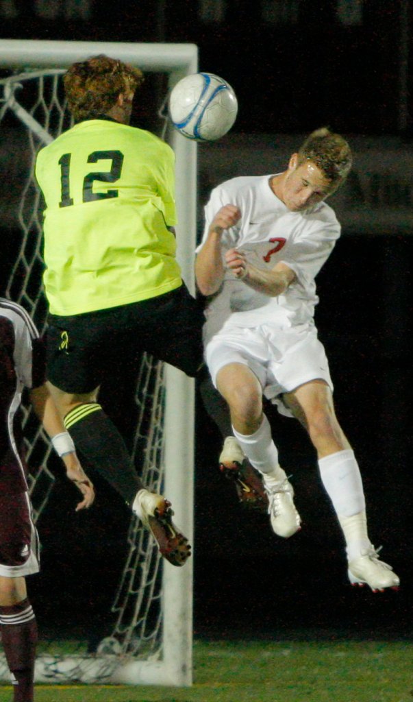 Windham goalkeeper Dana King, who earned his eighth shutout of the season, collides with Austin Downing of Scarborough while going for the ball.
