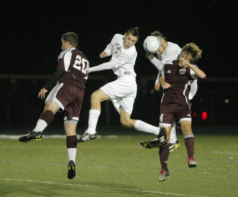 Mitch Hodge, left, and Robbie Lentine of Windham compete for the ball with J.D. Hermann and Andrew Jones of Scarborough.