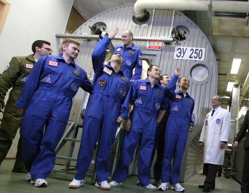 An international crew poses outside a set of windowless modules after a grueling 520-day simulation of a flight to Mars on Friday in Moscow. The all-male crew of three Russians, a Frenchman, an Italian-Colombian and a Chinese successfully completed the experiment intended to simulate the constricted and isolating conditions of space travel.
