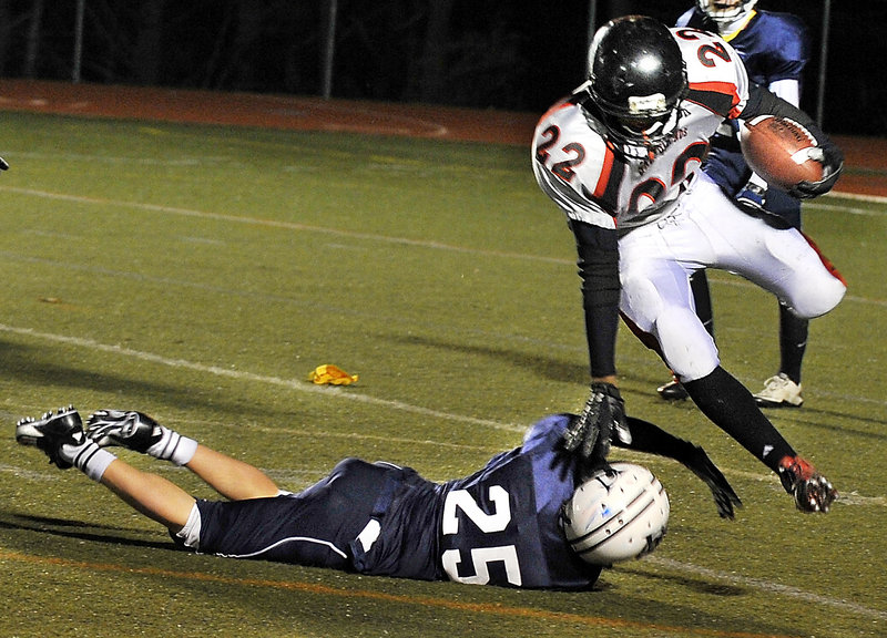 Quincy Thompson of Lisbon keeps his balance while attempting to dodge past Matt Woodbury of Yarmouth during the first half of Yarmouth’s 38-0 victory Friday night.