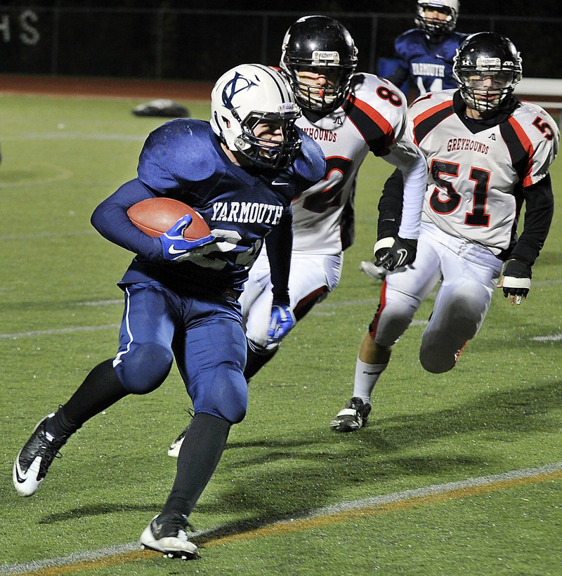 Anders Overhaug, who scored two touchdowns for Yarmouth, runs past Brandon Laurelez, left, and Dalton Dunphy of Lisbon during the first half of the Clippers’ 38-0 win in the Western Class C semifinals.