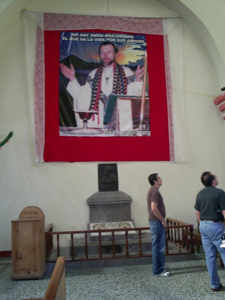 A photograph of the Rev. Stanley Rother is displayed inside the church he served in remote Santiago Atitlan, Guatemala. Atop the photo are the words, There is no greater love than to give your life for your friends.