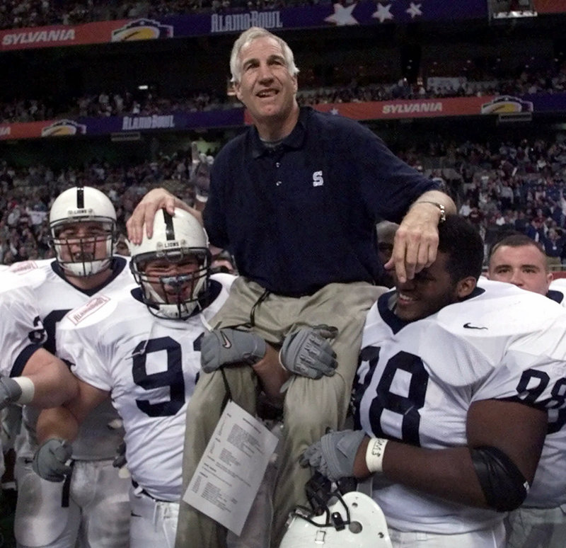 Penn State players carry defensive coordinator Jerry Sandusky off the field after a 1999 victory. Sandusky was arrested Saturday and released on $100,000 bail after being arraigned on 40 criminal counts involving eight boys.
