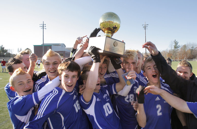 Game over, title won, and Andrew Murry, 10, the Falmouth co-captain, lifts the Gold Ball with his teammates after the Yachtsmen captured the Class B boys soccer state championship with a 2-1 victory Saturday at Hampden Academy that sent Camden Hills to its only loss of the season.