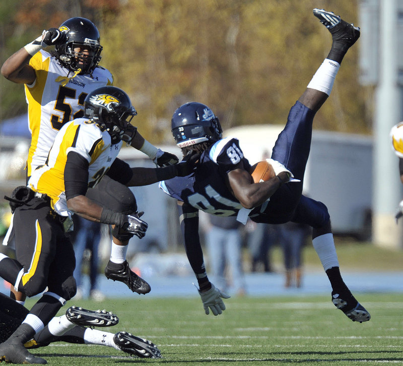 Denzel White, 52, and Tye Smith of Towson tackle UMaine’s Maurice McDonald after a reception in Saturday’s game at Orono. The Black Bears were beaten, 40-30.
