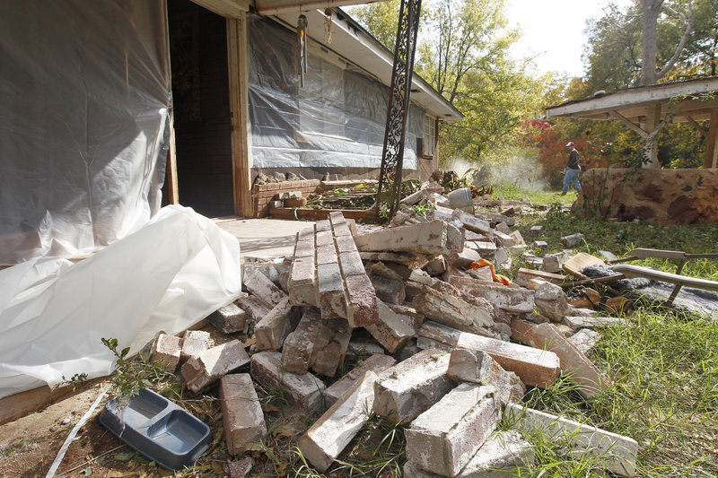 Chad Devereaux cleans up bricks Sunday that fell from his in-laws’ home in Sparks, Okla., after two earthquakes hit the area in less than 24 hours. The state has experienced a dramatic increase in quakes, from about 50 a year before 2009 to 1,047 last year.