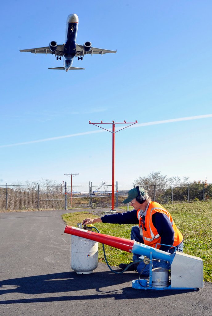Keith Lynds, a maintenance worker at the Portland International Jetport, demonstrates a propane-powered noise cannon used to scare away birds by emitting a rifle-like blast.
