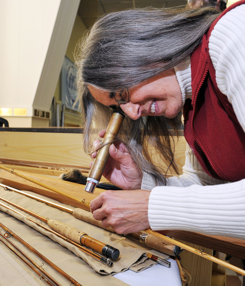 Kathy Scott uses a microscope to inspect the threads on a guide wrap on a bamboo rod. Fewer than 12 people in Maine are estimated to make bamboo rods for clients.