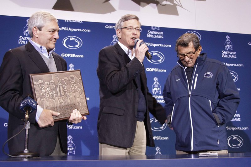 Penn State President Graham Spanier, left, and athletic director Tim Curley, center, present head football coach Joe Paterno with a plaque commemorating his 409th collegiate win Oct. 29. Curley and another administrator, Senior Vice President Gary Schultz, have since stepped down amid charges of failing to report allegations of child sex abuse by a former coach. Paterno’s weekly news conference is slated for today.