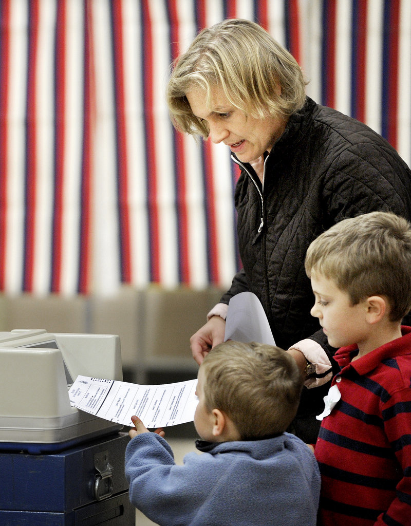 Reid, 3, and Henry, 5, help their mom, Amy Haile, cast her ballot in Westbrook on Tuesday night.