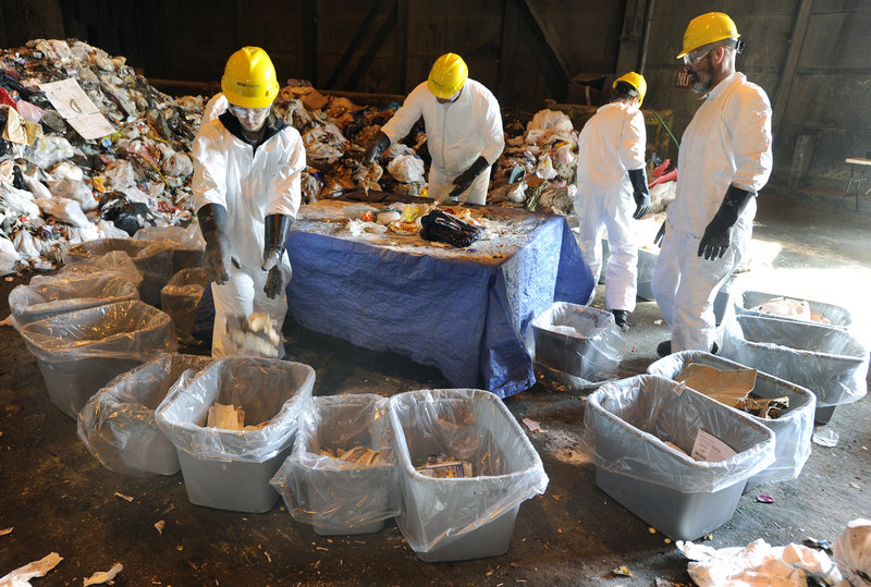 A crew hired by the University of Maine sorts trash Wednesday at the ecomaine waste plant in Portland for a study on recycling. The crew sorted about 400 pounds of trash collected in Scarborough into 30 bins.