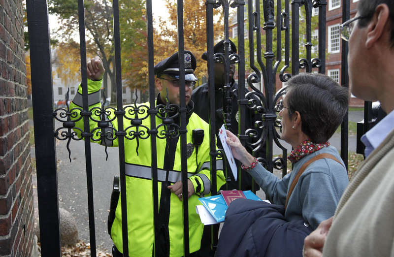 Olga Fradejas, a Spanish teacher at Harvard University, second from right, is turned away from an entrance to the school by police in Cambridge, Mass., Thursday. Police told her to use one of the school’s designated open entrances. Olga Fradejas, a Spanish teacher at Harvard University, second from right, is turned away from an entrance to the school by police in Cambridge, Mass., Thursday. Police told her to use one of the school’s designated open entrances.