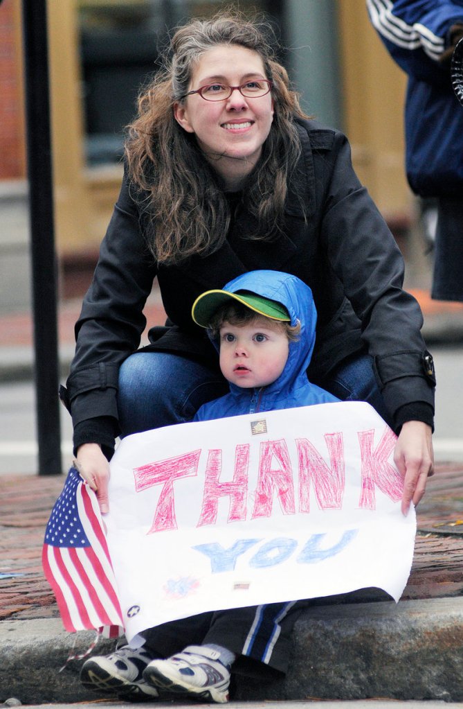 Emily Read of Scarborough and her son Teddy, 2, show their support for veterans during the Veterans Day Parade in Portland on Friday. Dozens of marchers representing veterans, military units and the city’s police and fire departments marched from Longfellow Square to City Hall.