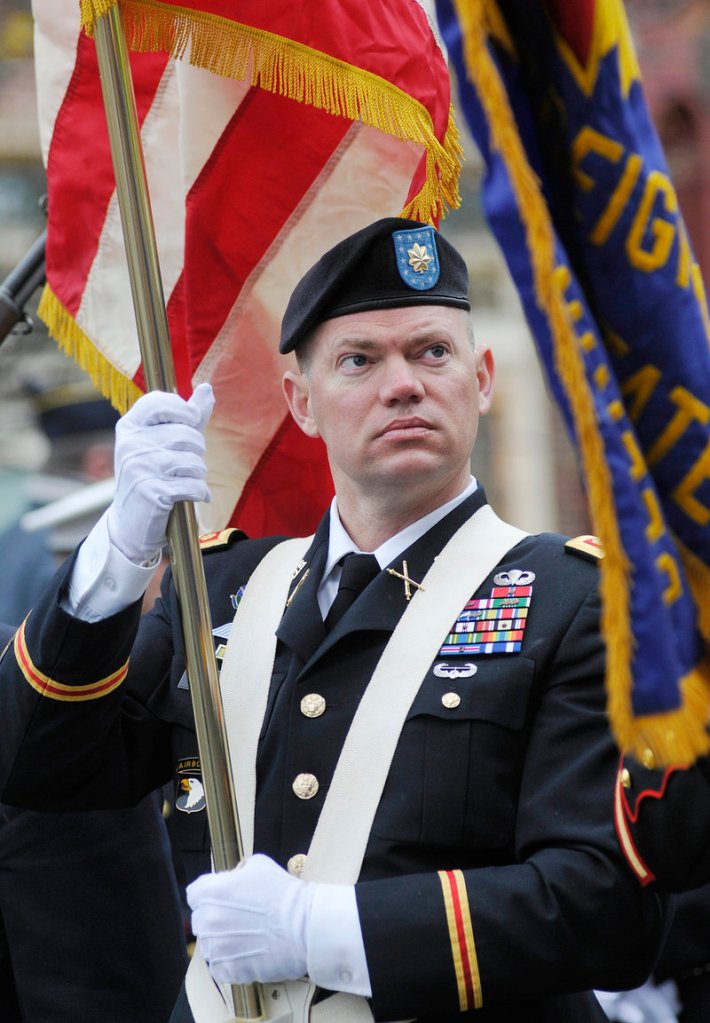 Maj. Todd Mitchell, a color guard with Veterans of Foreign Wars Post 6859, carries the colors before the start of the Veterans Day parade in Portland on Friday. Mitchell served in the Army.