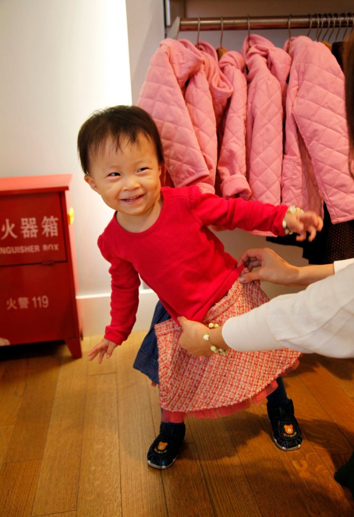 A shopper checks the fit on a skirt for her daughter at the Gap store in Shanghai. As the American market continues to sputter, Gap, Levi Strauss and other U.S. retailers are updating their business plans to include the world’s second-largest economy, as well as the rest of growing Asia.