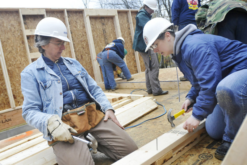 Karen Boudriault of Waterboro and Karen Hewes of South Portland work to help Habitat for Humanity build houses in Freeport on Friday. Habitat for Humanity is building three homes for low-income families on South Street.