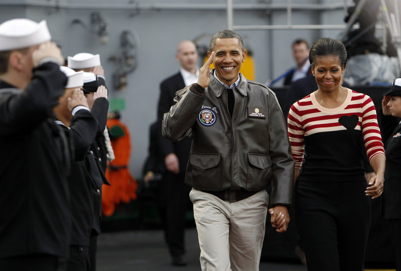 President Obama and first lady Michelle Obama walk on the flight deck of the USS Carl Vinson for the Carrier Classic NCAA college basketball game Friday in Coronado, Calif.