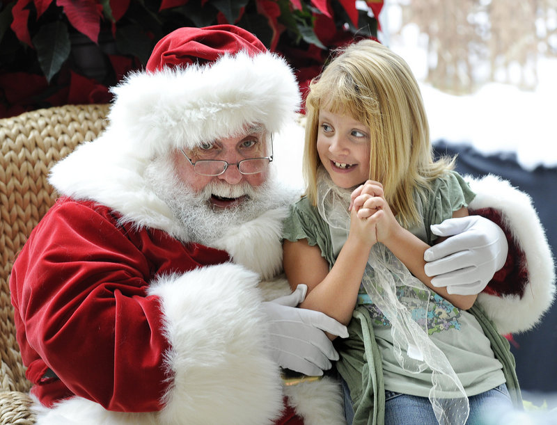 Jianna Sperdakos, 7, of Hebron visits with Santa at the Maine Mall on Saturday. The mall is back to full capacity, and its management expects that new stores there will boost shopping traffic this holiday season.