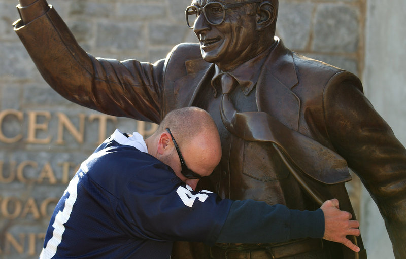 Penn State fan Gary Buck of West Grove, Pa., hugs a statue of former Penn State head coach Joe Paterno at Beaver Stadium before Saturday’s football game between the University of Nebraska and Penn State in State College, Pa.