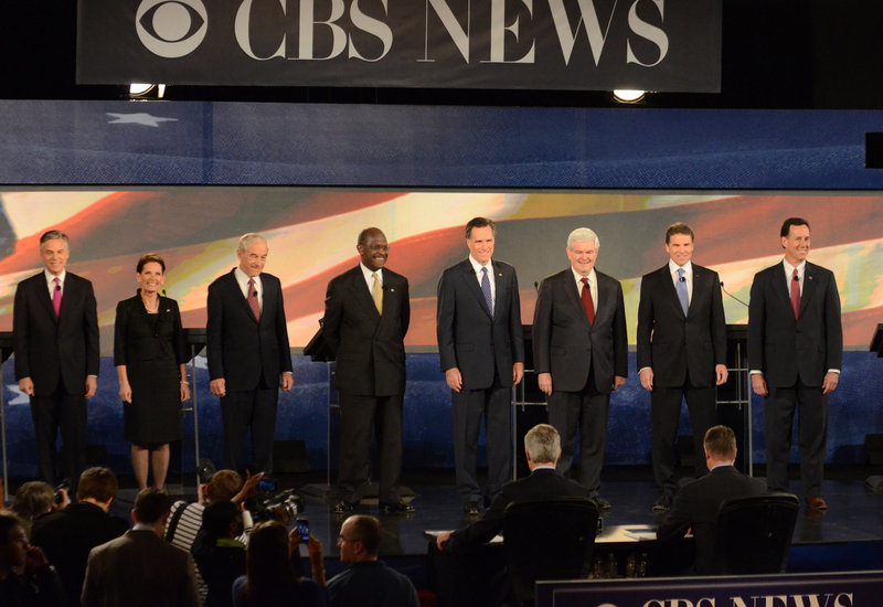 Herman Cain, from left, Mitt Romney, Newt Gingrich, and Rick Perry take the stage at Saturday’s GOP debate. Jon Huntsman, Michele Bachmann and Rick Santorum also participated.