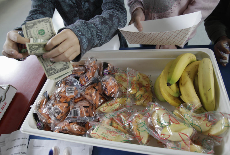 A student pays for fruits and vegetables at a school in Palo Alto, Calif. Congress wants to keep pizza and french fries in the nation's school lunch programs.