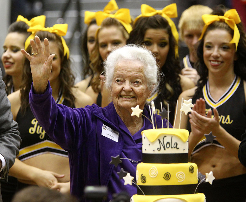 Nola Ochs, center, of Jetmore, Kan., celebrates her 100th birthday with friends, family and cake during halftime of the Fort Hays State University men’s basketball game in Hays, Kan., on Tuesday. Ochs’ actual birthday is next week.
