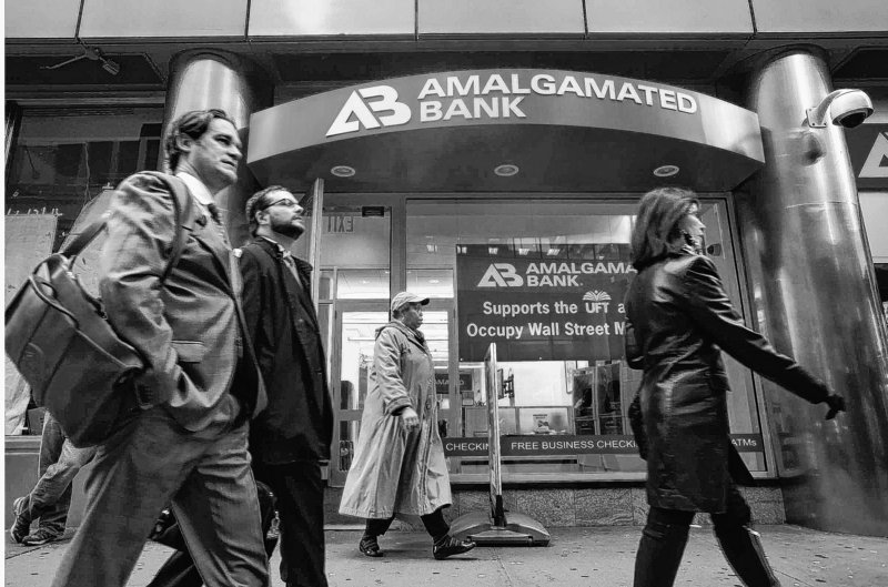 Pedestrians pass the Amalgamated Bank at 52 Broadway in lower Manhattan in New York earlier this month. Amalgamated Bank, a union-owned bank founded in 1923, supports the Occupy Wall Street movement.