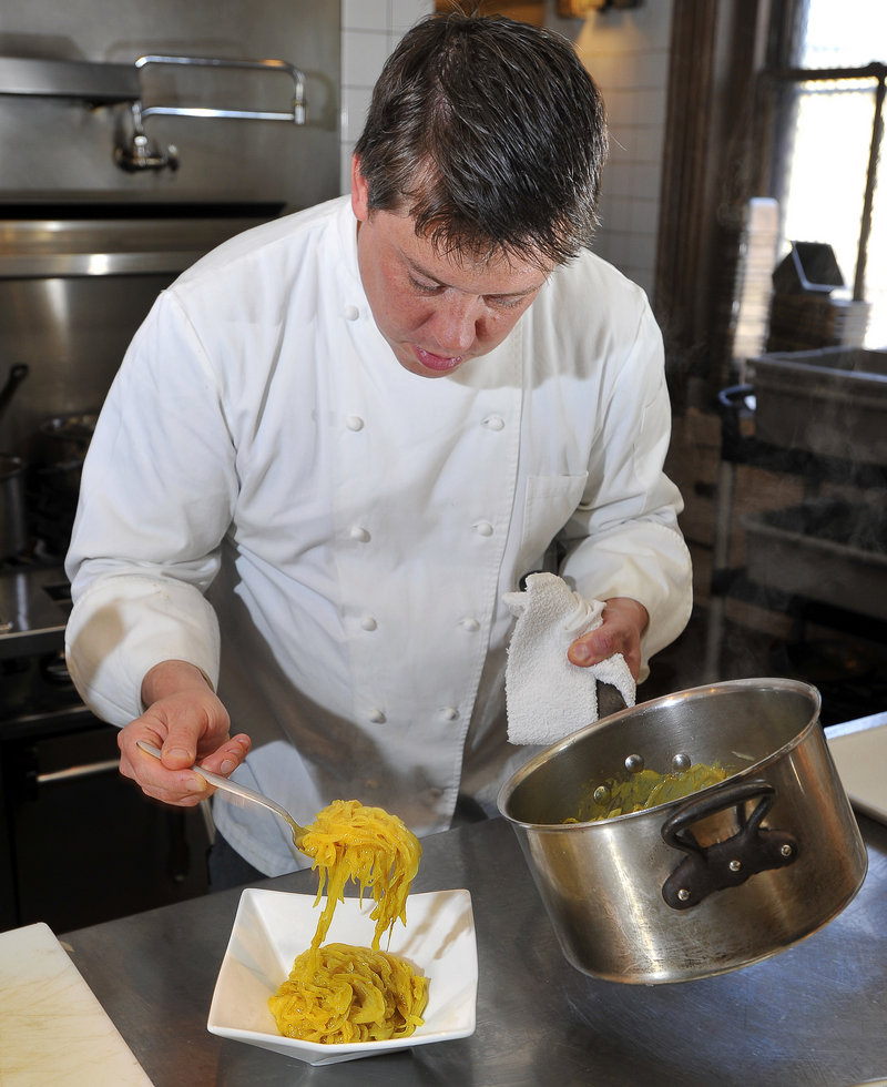 Chef Larry Matthews Jr. of Back Bay Grill in Portland spoons his curried onions into a serving dish.