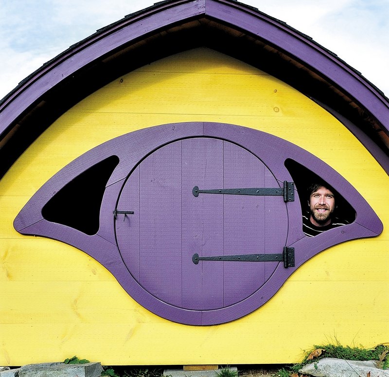Rocy Pillsbury looks out from inside a Hobbit Hole playhouse. A Bangor radio personality plans to live in a Hobbit Hole to raise money for heating assistance.