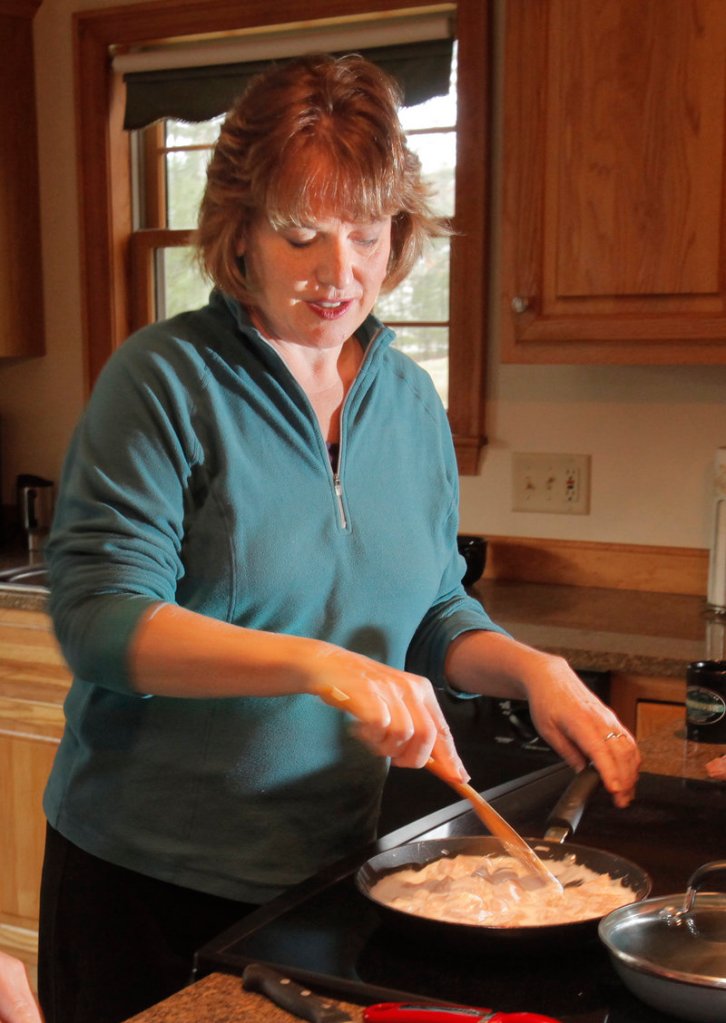 Marcia Scott stirs the chicken in coconut milk.