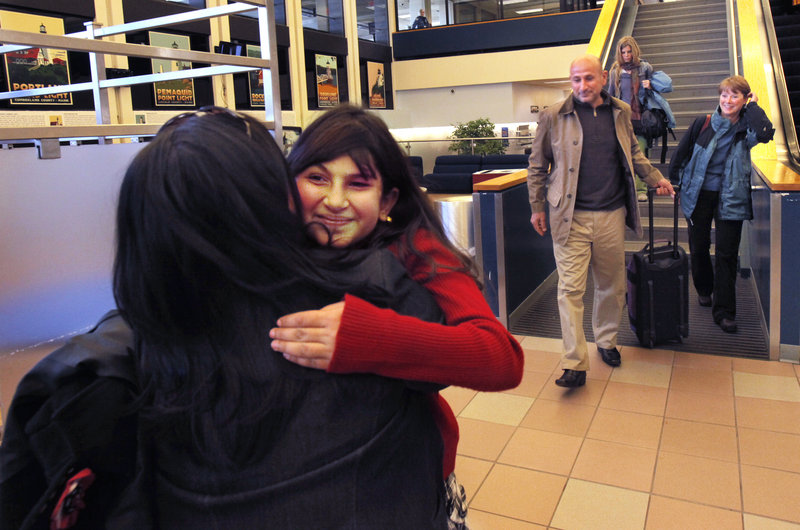 Noora Afif Abdulhameed hugs Tasha Horton after arriving at the Portland International Jetport with her father, Afif, on Monday.