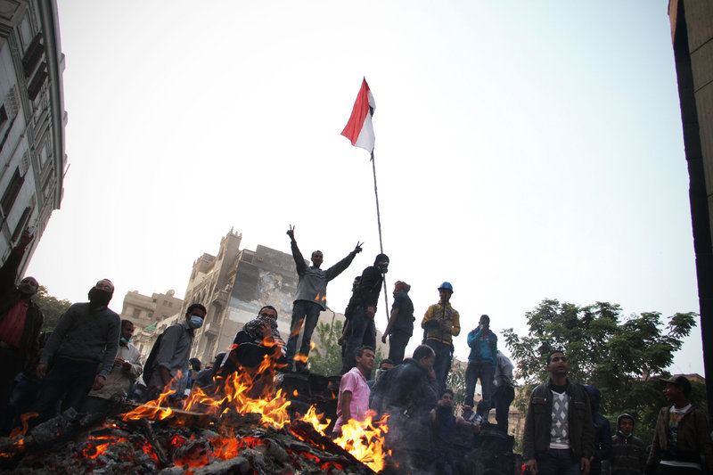 A protester flashes the victory sign Monday during clashes with riot police in Cairo. Security forces fired tear gas at several thousand protesters in the third day of violence that has killed at least 26 people and has turned into the most sustained challenge yet to the rule of Egypt’s military.