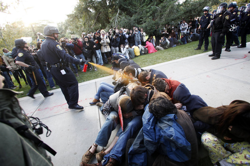 University of California, Davis police Lt. John Pike uses pepper spray to move Occupy UC Davis protesters while blocking their exit from the school’s quad Friday.