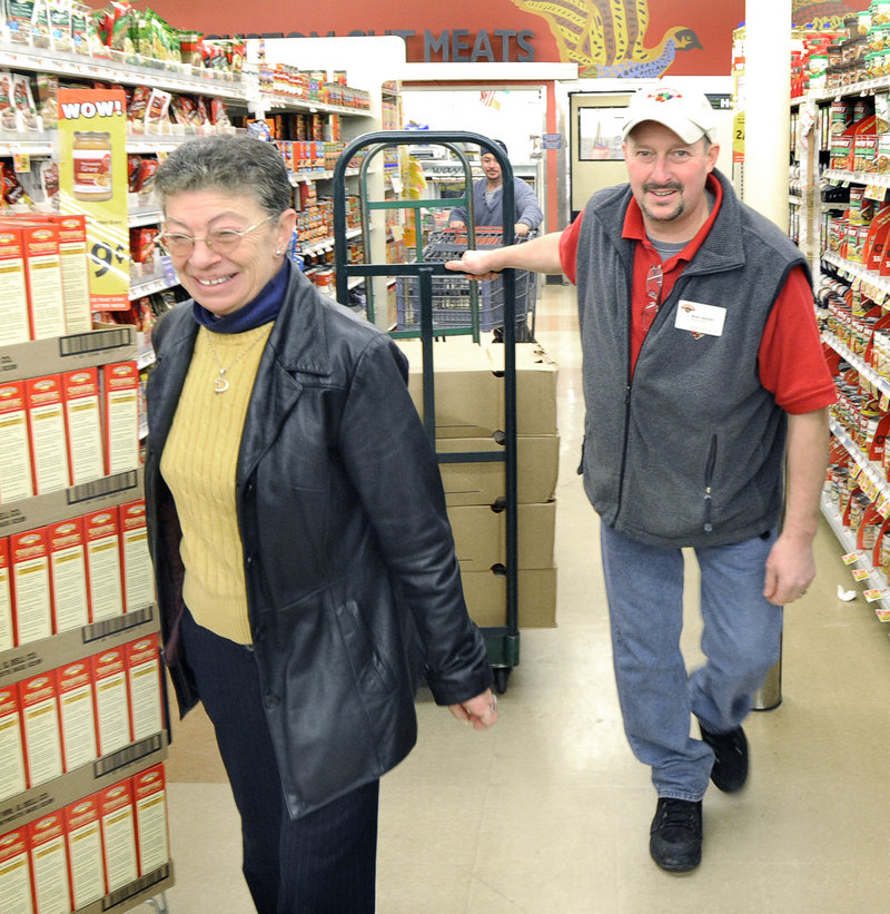 Debi Hubbard gets help Tuesday from meat manager Wally Bennett as she picks up 24 turkeys at Hannaford in South Portland for the Thanksgiving dinner she cooks at the VFW hall.
