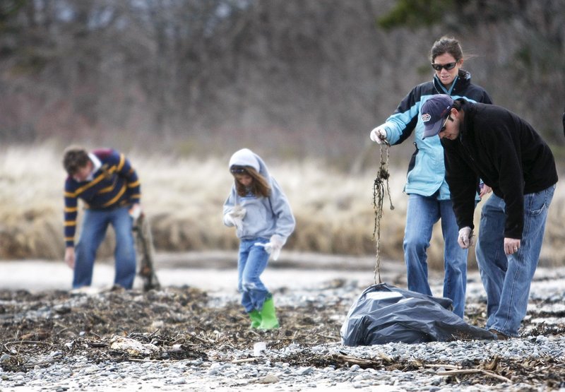 Volunteers pick up trash on Crescent Beach on Earth Day last year. A reader applauds a Girl Scout who called attention to widespread littering.