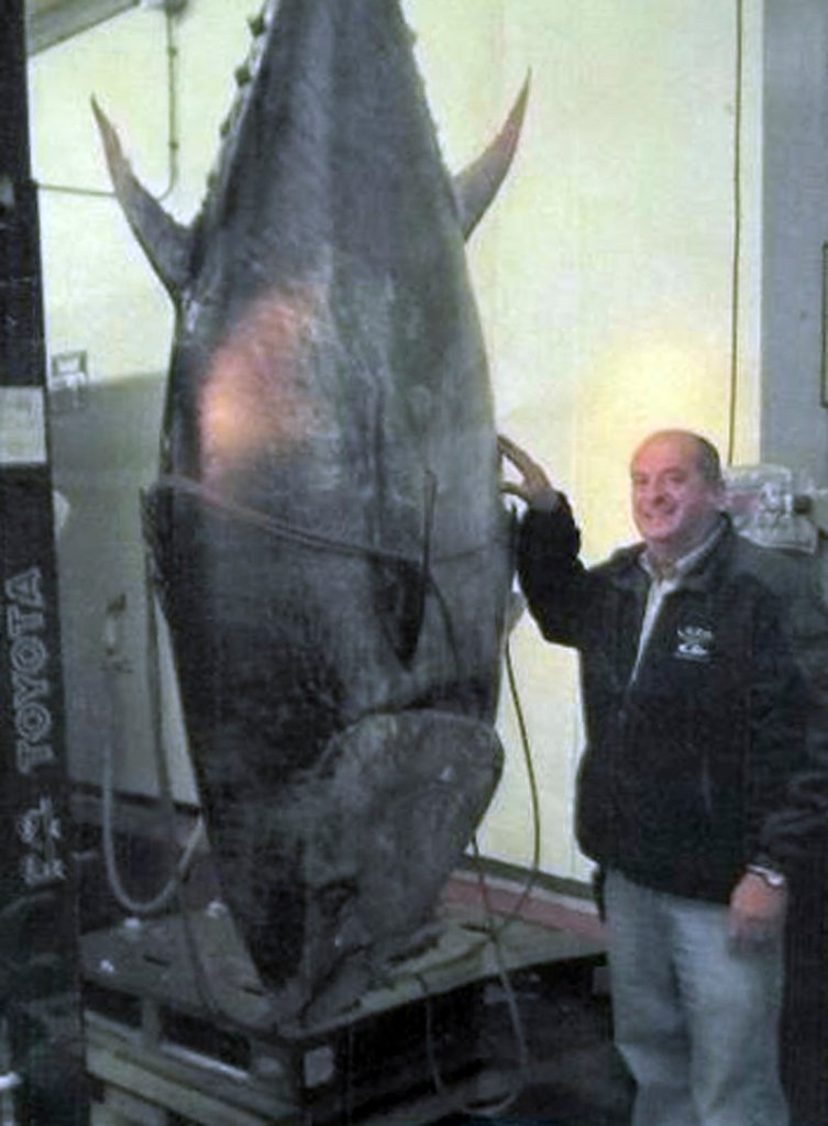 Fishing boat owner Carlos Rafael poses Nov. 12 in New Bedford, Mass., with an 881-pound tuna that was caught as his crew set a net to capture bottom-dwelling fish.
