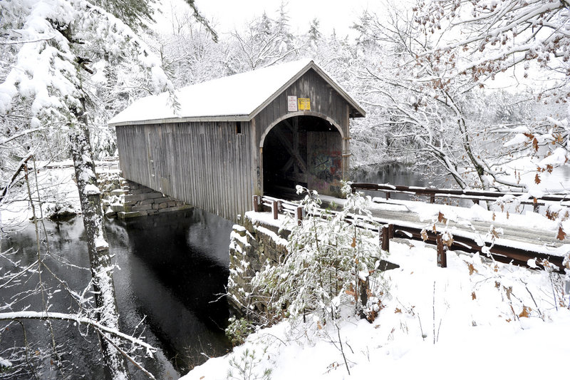 A covered bridge over the Presumpscot River in Windham sports a coat of white after a storm dumped up to 15 inches in some areas.