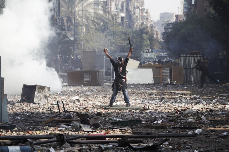 A protester gestures to Egyptian riot police during clashes near Tahrir Square in Cairo on Wednesday. The United Nations condemned the violence.