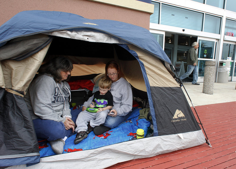 Nicki Lawrence, left, her daughter Windy LaFerney and grandson Caisen, 4, wait in their tent in front of Best Buy in Mesquite, Texas, on Monday. They set up their tent late Sunday so they can be first in the store Friday to get a deal on a TV and other items for Christmas.