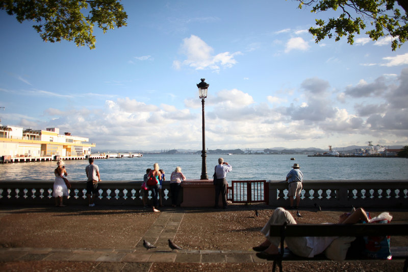 Tourists look out from the pier near the cruise ship terminal in Old San Juan, Puerto Rico, on Wednesday. The Caribbean anticipates another surge in visitors this winter, but officials warn that the amount the average tourist spends probably will decline.
