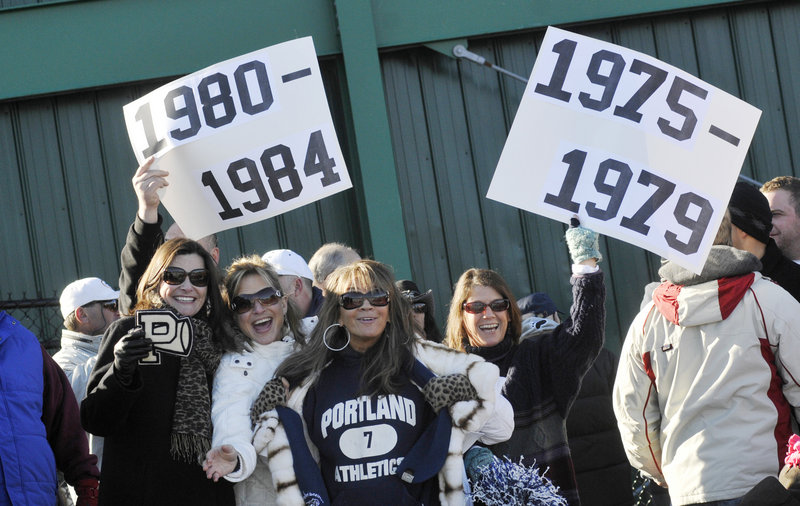 Former Portland High students, from left, Kelly Hasson, Theresa DiPietro, Lucia DiPietro Benatar and Lisa Martin show off their pride as alumni get together for a halftime ceremony during the annual Thanksgiving Day football game between crosstown rivals Deering and Portland at Fitzpatrick Stadium in Portland on Thursday.