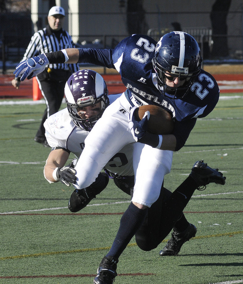 Nick Volger of Portland attempts to break away from James Doyle of Deering during the 100th Thanksgiving Day game between the teams Thursday at Fitzpatrick Stadium. Deering's defense dominated in a 33-0 victory.